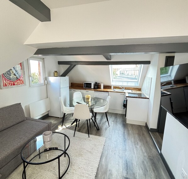 A compact living space with a kitchenette, a dining area, and a sofa.