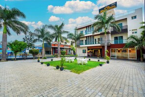 A hotel with a courtyard, outdoor seating, and a sign for the Bella Vento restaurant.