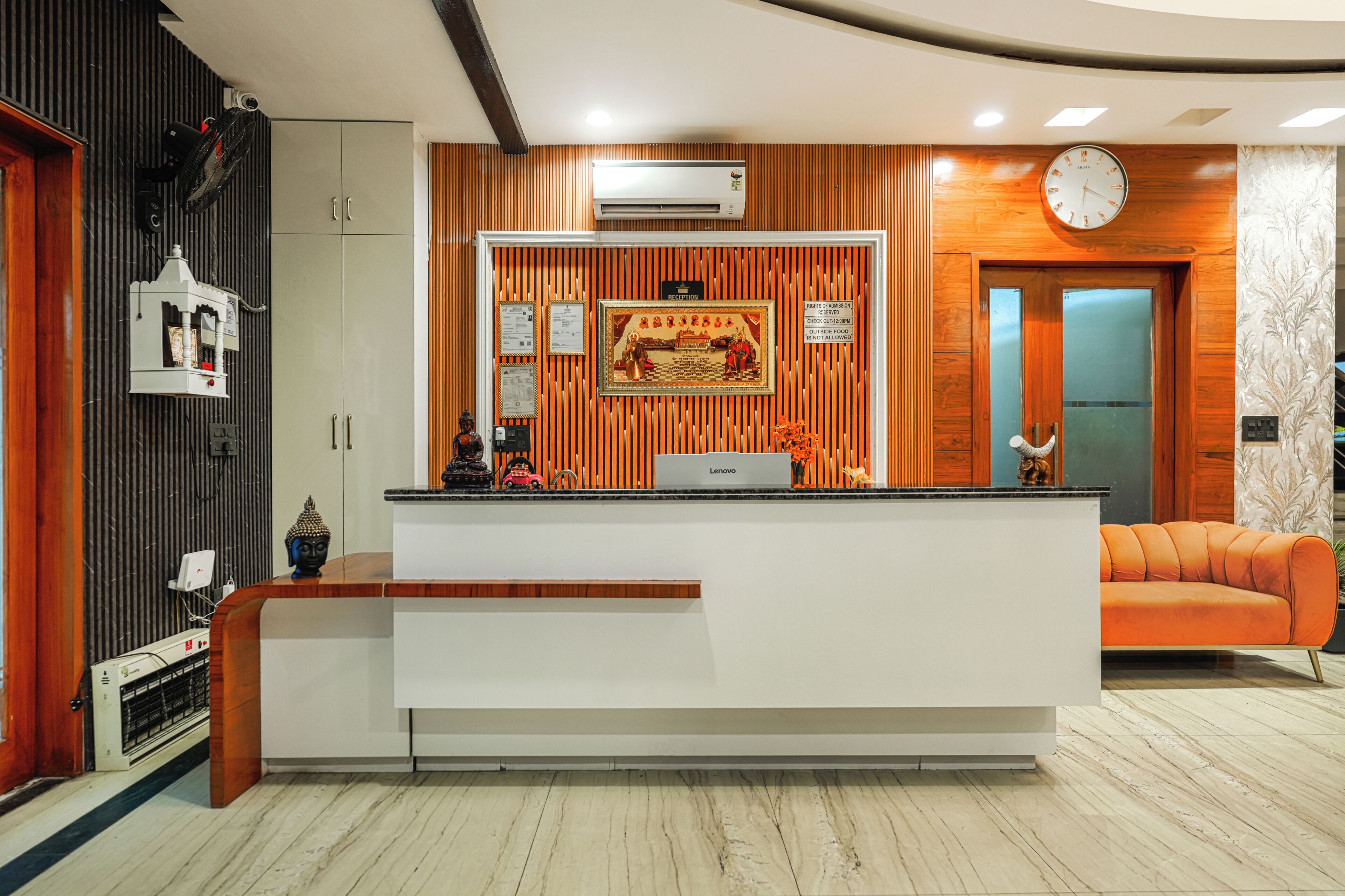 A reception area with a reception desk, a clock, and a sofa.