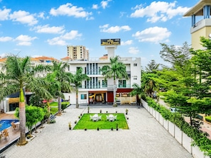 A hotel with a rooftop garden, outdoor seating, and a sign indicating it is a restaurant and party hall.