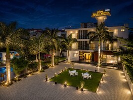 Un hotel con piscina, zona de estar al aire libre y entrada bien iluminada.