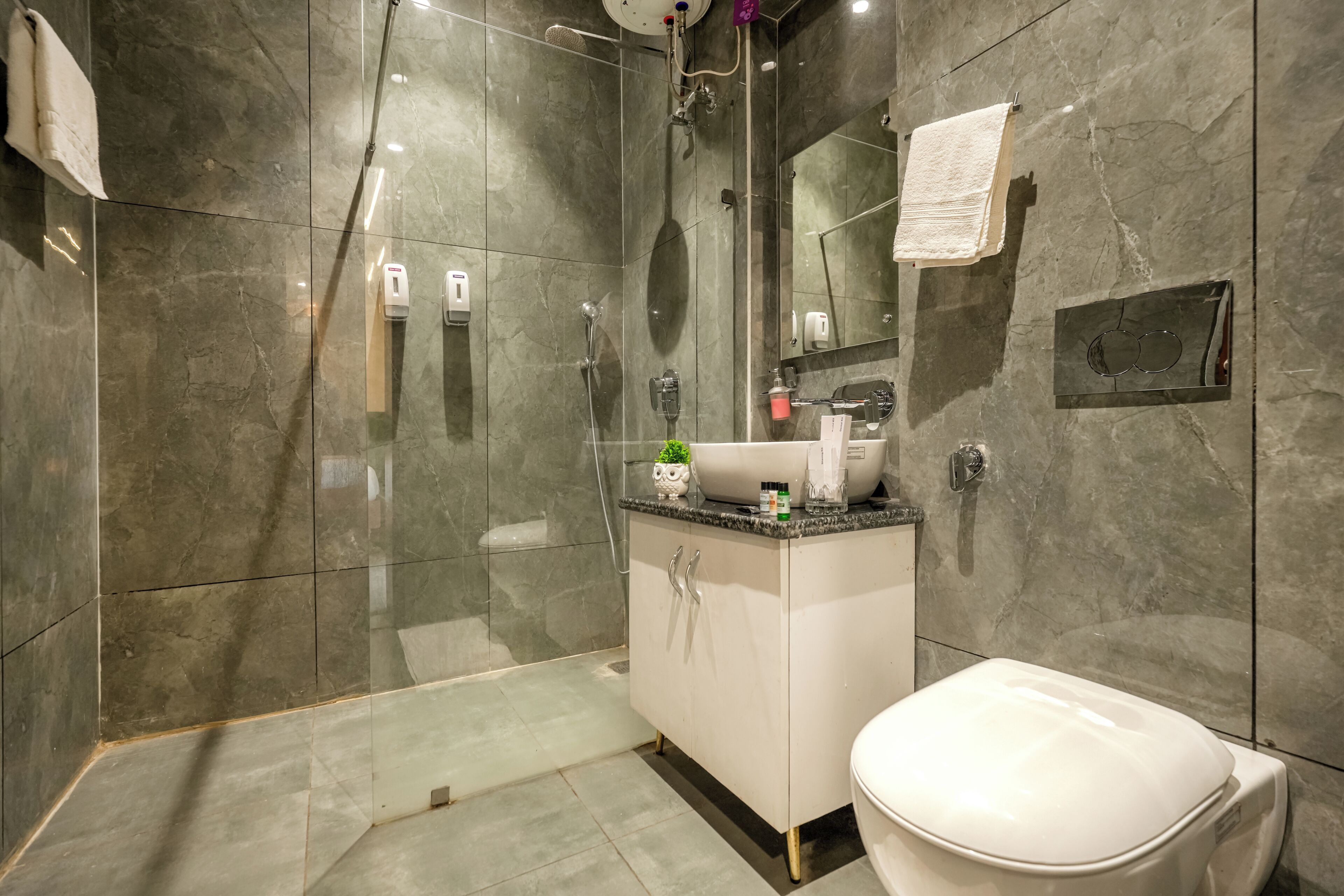 Une salle de bain moderne avec une douche à parois de verre, un lavabo blanc et des toilettes.