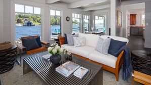 A spacious living area with a white sofa, a coffee table, and a view of a lake. - Chester Back Harbour Exclusive providing direct access to water via private dock (Chester Basin)