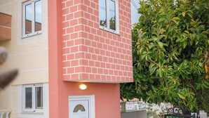 A two-story building with a red brick section and a beige section. - Vila Myrtaj (Ksamil)