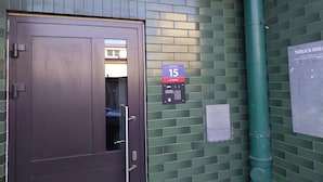 A door with a keypad lock, a green tiled wall, a sign with the number 15, and a green pipe. - Holiday Apartment for 2 People, Swinoujscie (Swinoujscie)
