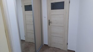 A hallway with a sliding glass door and a wooden door with a window. - Holiday Apartment for 2 People, Swinoujscie (Swinoujscie)