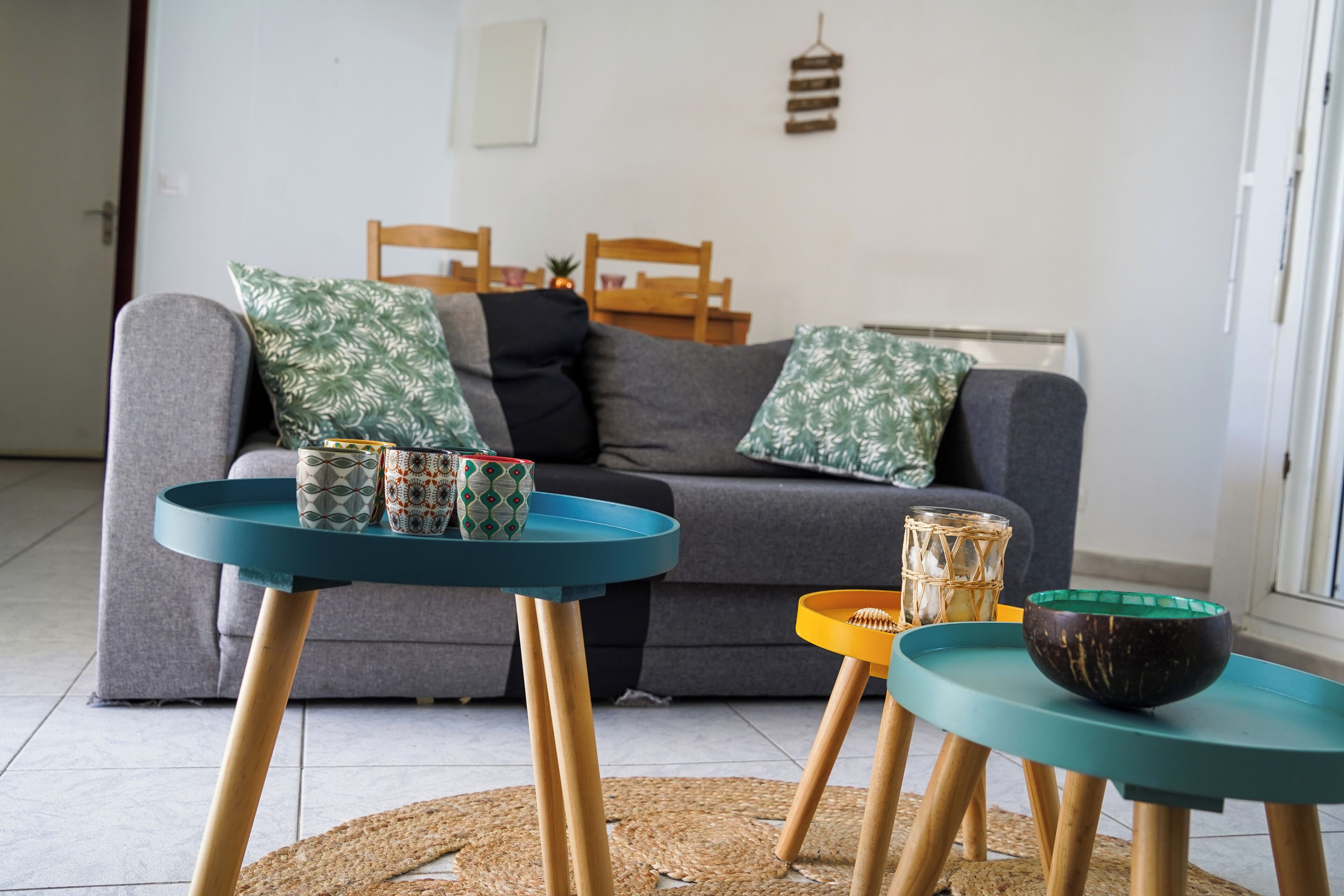 A living room with a sofa, two side tables, and decorative items.