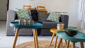 Een woonkamer met een bank, twee bijzettafeltjes en decoratieve accessoires.