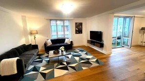 Una sala de estar con sofá, mesa de centro y alfombra geométrica.