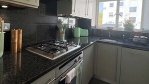 Una cocina moderna con estufa a gas, horno y ventana que ofrece luz natural.