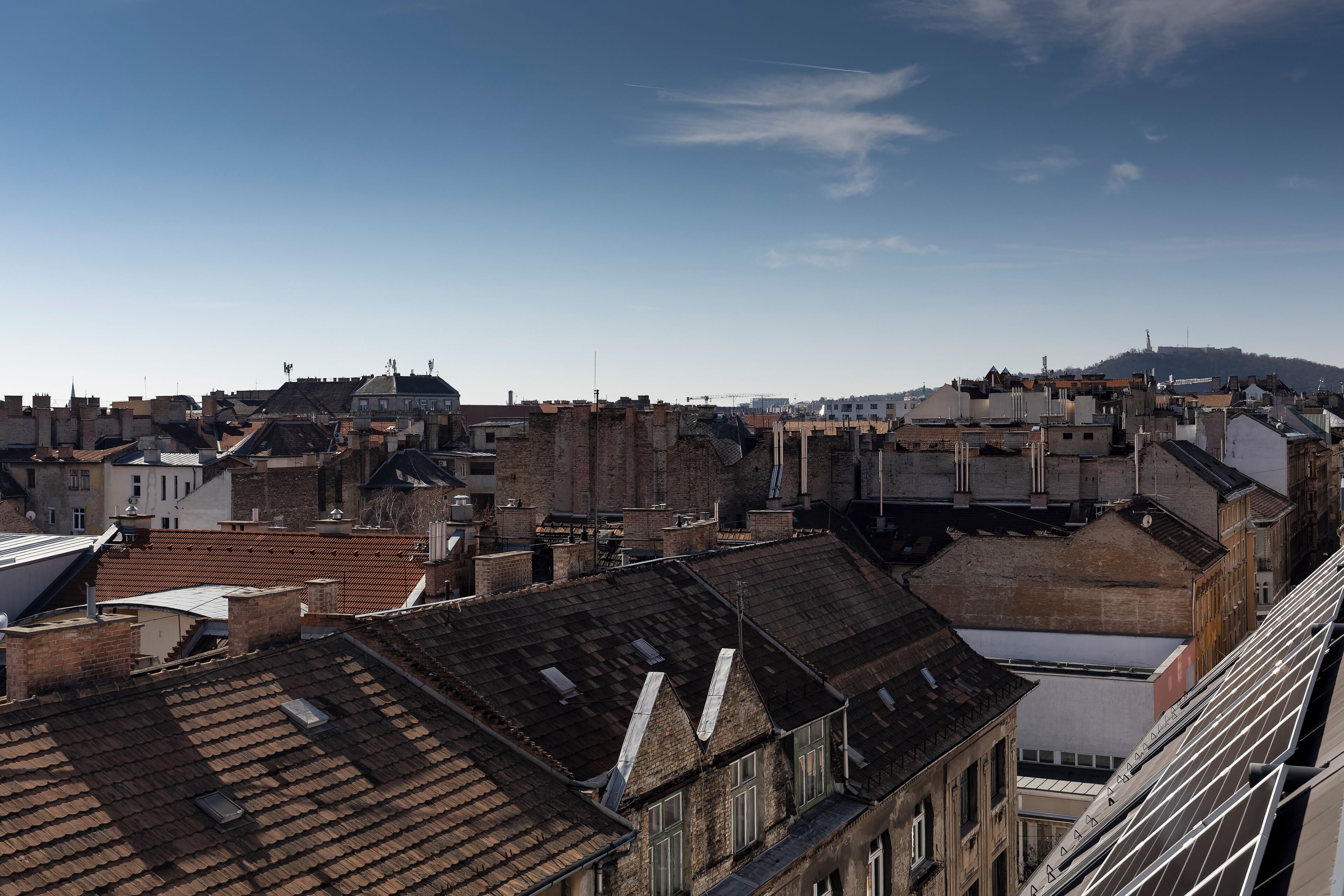 Un paisaje urbano con diversos tipos de edificios, algunos con techos planos y otros con techos inclinados.