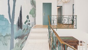 A staircase with a mural, a wooden railing, and a door in a hallway. - 700 m from the beach, House for 8, garden (L'Epine)
