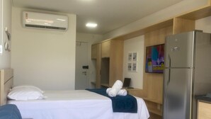 A hotel room with two beds, a kitchenette, a refrigerator, and an air conditioning unit. - Nawa 01 com piscina privativa by LP (Tamandaré)