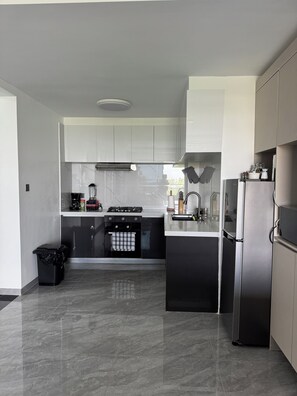 Eine moderne Küche mit Gasherd, Backofen und Edelstahlkühlschrank.