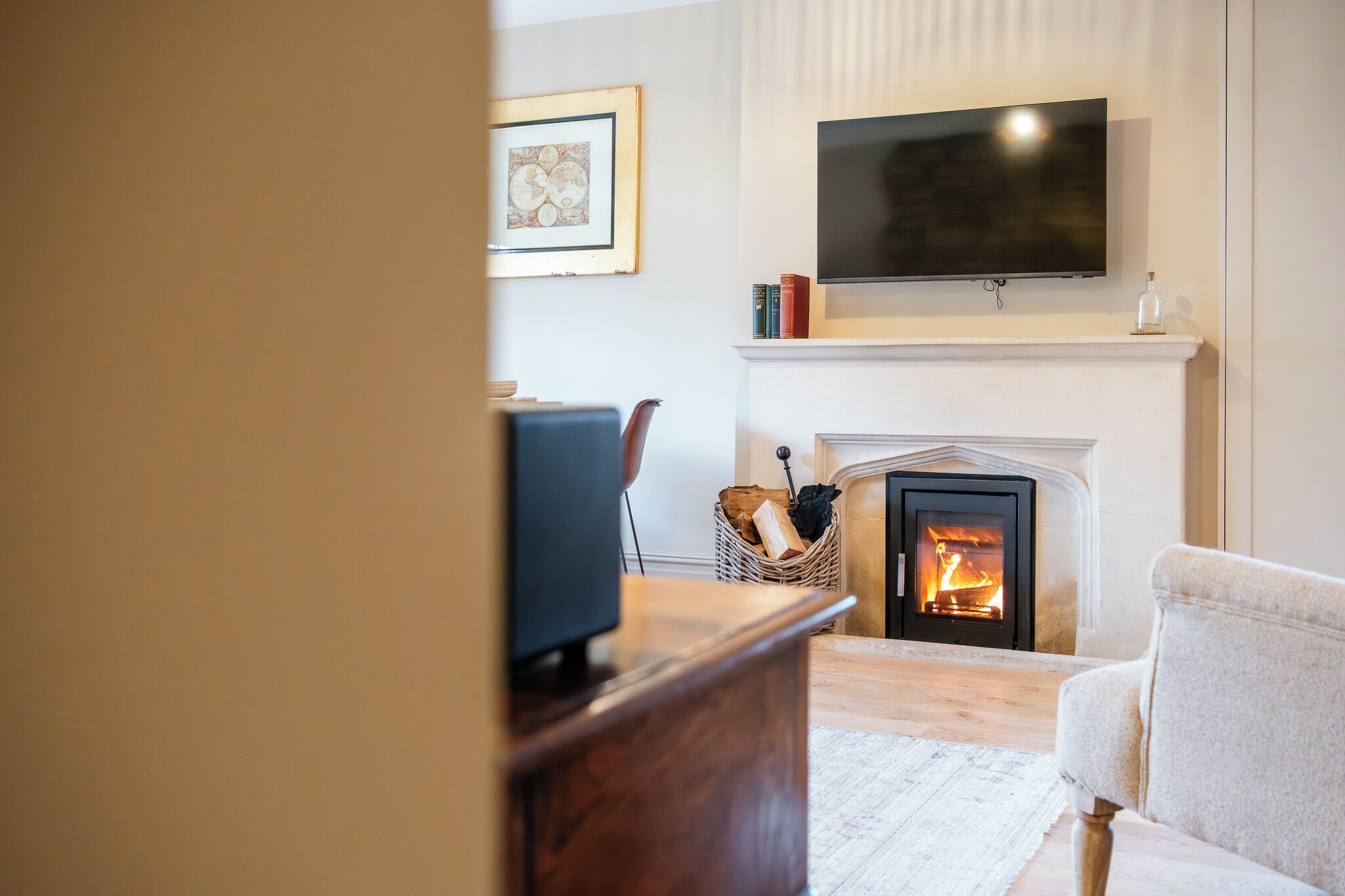A living room with a fireplace, a television mounted above it, and a framed picture on the wall.