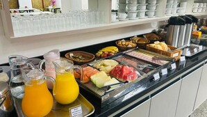Un buffet de petit-déjeuner proposant une variété de fruits, de jus et de pains.