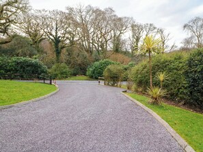 Un camino de grava en un parque con árboles y arbustos.