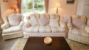 A living room with a sofa set, two lamps, a table with a bowl, and a refrigerator. - Lugdine Lodge (Glengarriff)
