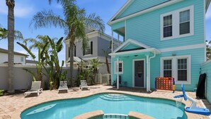 A swimming pool with lounge chairs, a hot tub, and a two-story house with a balcony. - New! Luxury Reunion Villa | Theater • Pool • Game Room (Kissimmee)