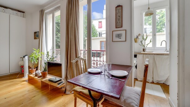 Un espace repas avec une table en bois, des chaises et une vue sur l’extérieur.