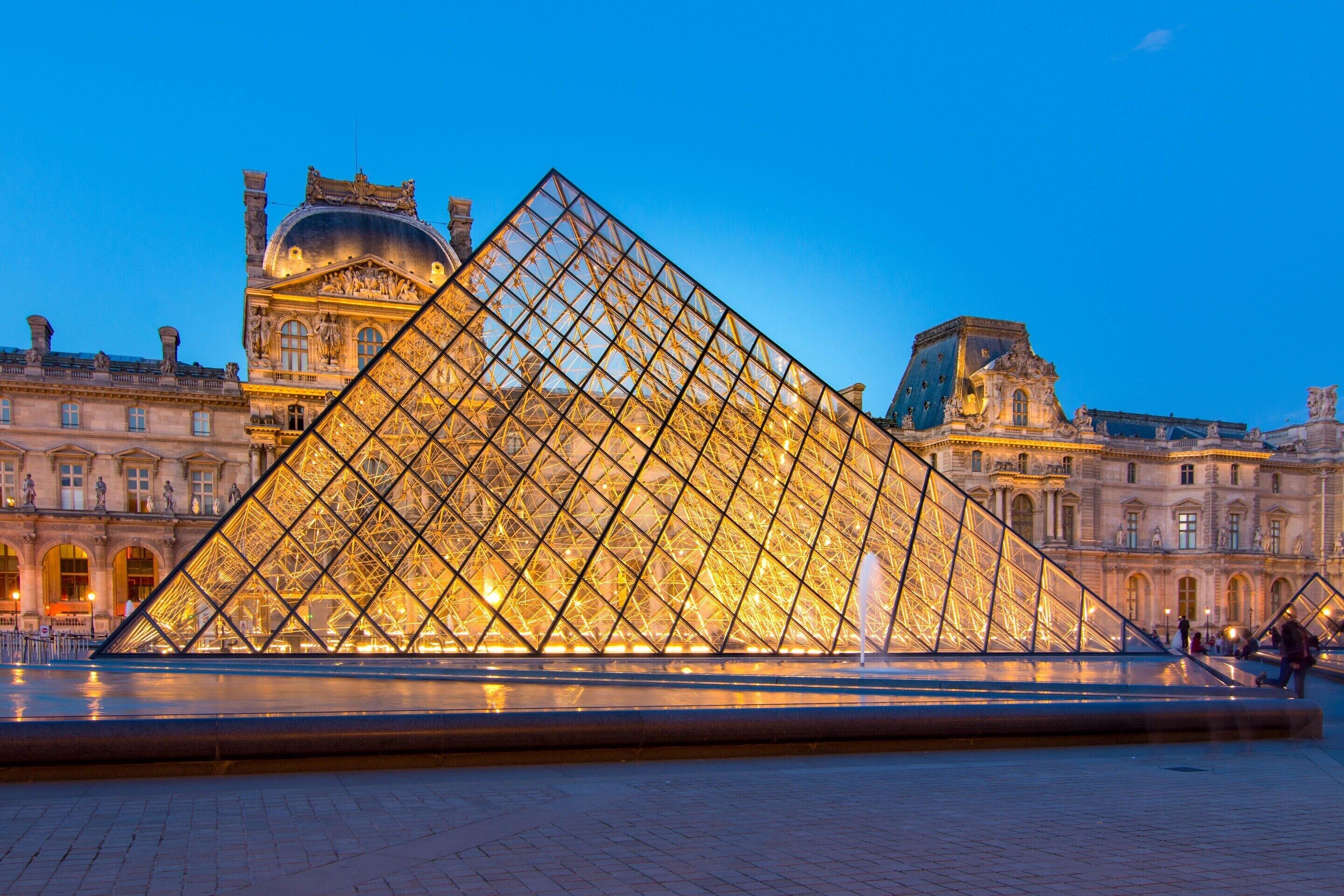 The Louvre Pyramid with its glass structure and the surrounding classical architecture.