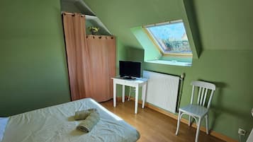 Makuuhuoneessa on sänky, työpöytä, tuoli, televisio ja kattovalokuvio.