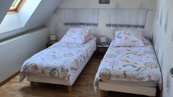 Un dormitorio con dos camas, un tragaluz y un detalle decorativo en la pared.