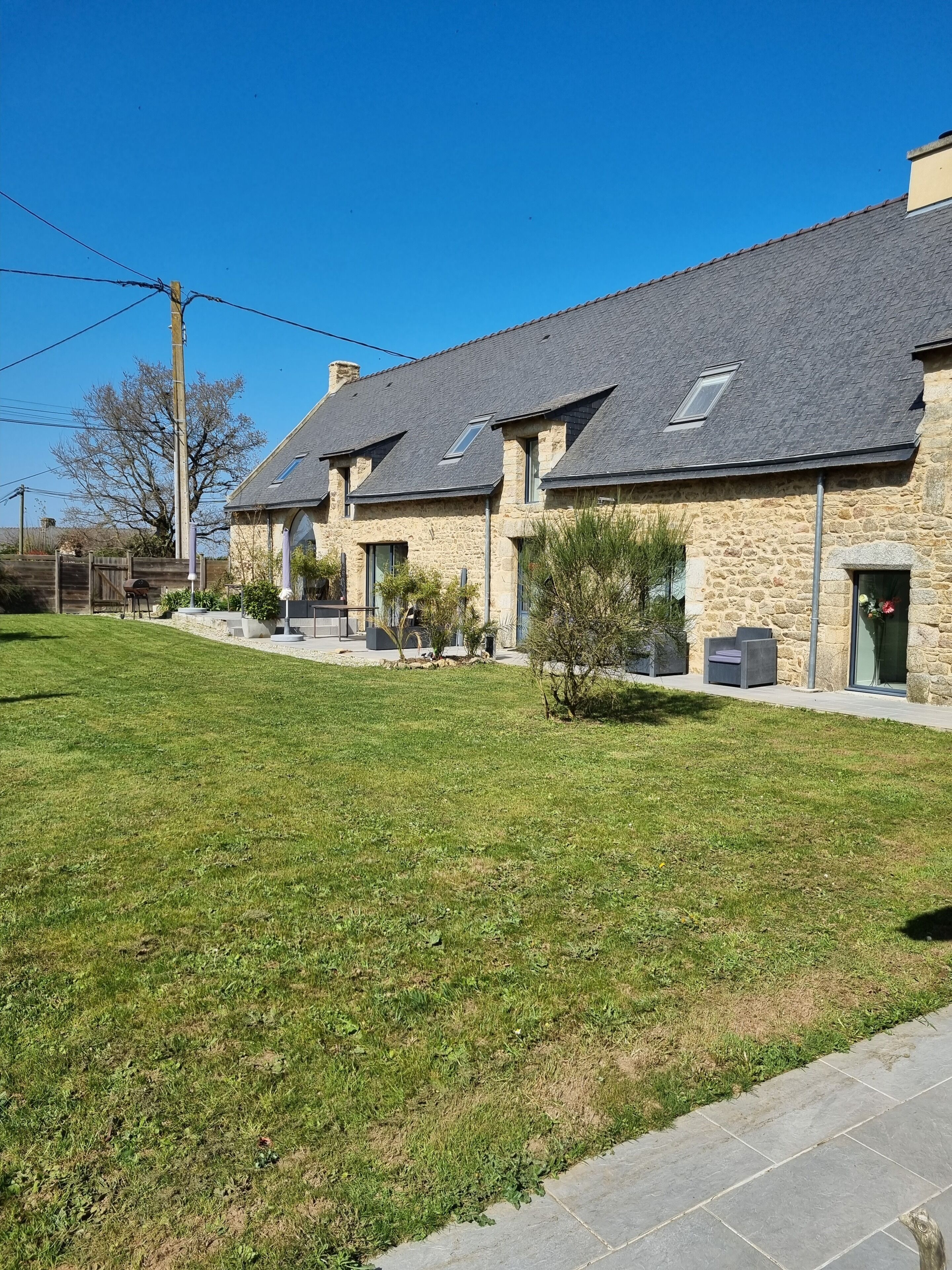 A row of stone buildings with a grassy lawn and a paved walkway.