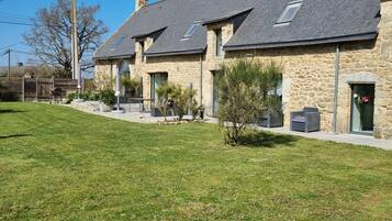 A row of stone buildings with a grassy lawn and a paved walkway.