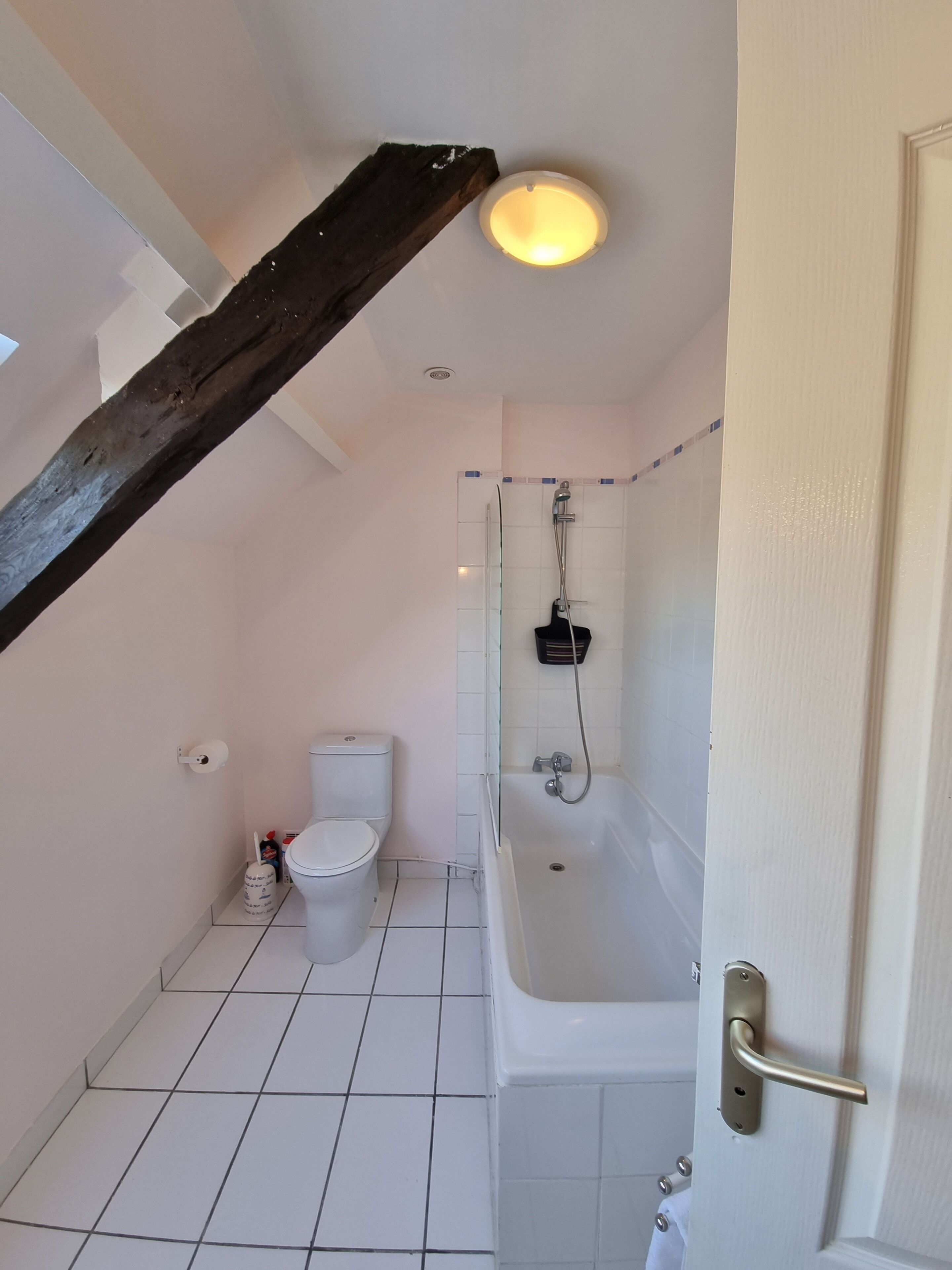 A small, clean bathroom with a toilet, sink, and bathtub.