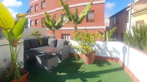 A rooftop terrace with a sofa, a table, and potted plants. - Nice house with terrace (San Cristóbal De La Laguna)