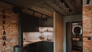 Una cocina con pared de ladrillo, estufa y lavabo.