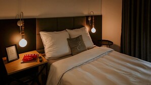 A hotel room with a bed, bedside table, lamp, and curtains. - Large holiday home with a jacuzzi on the terrace (Kościerzyna)