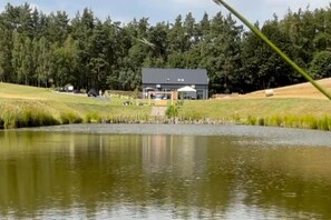 A lakeside property with a building, grassy areas, and a pond.