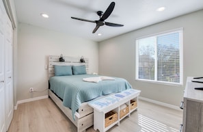 A bedroom with a bed, a ceiling fan, a window with blinds, a bedside table, and a nightstand. - MANATEE CROSSING 3Bd/3Ba w/ Studio, Private Dock & Kayaks, Weeki Wachee, FL (Spring Hill)