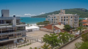 A coastal building with multiple floors, a rooftop terrace, and a view of the sea. - Mirante dos Ingleses (Florianopolis)