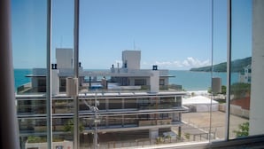 A modern multi-story building with balconies, large windows, and a view of the sea. - Mirante dos Ingleses (Florianopolis)