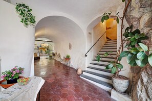 A hallway with a tiled floor, a staircase, and potted plants. - Apartment 'La Casa Del Marchese' with Private Terrace (Pietra Ligure)