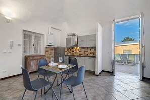 Une cuisine moderne avec un coin repas, une vue sur l’extérieur et un balcon.