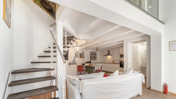 Un intérieur moderne comprenant un escalier, un coin repas et un lit.
