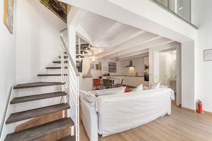 A modern interior with a staircase, a dining area, and a bed. - Apartment 'Casa Di Gaia' with Wi-Fi and Air Conditioning (Carloforte)