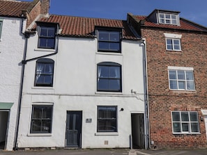 A two-story building with a white facade and red-tiled roof. - Marina House (Whitby)