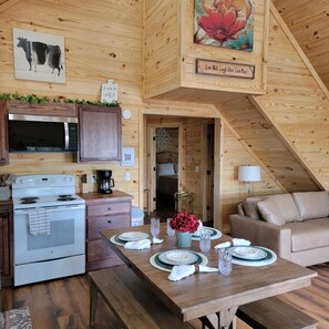 Ein gemütliches Blockhaus-Interieur mit Küche, Essbereich und Wohnzimmer.