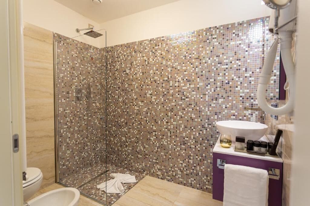Een badkamer met een douche, toilet en wastafel met spiegel.