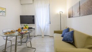 A compact living space with a dining area, a sofa, a flat-screen TV, and artwork on the walls. - Monte Ceneri, 71 - Modern, convenient and well-connected (Milan)