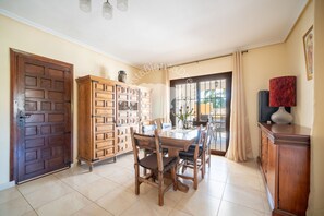 A dining area with a wooden table, chairs, a cabinet, and a door. - CostaBlancaDreams - Villa Los Pinos in Calpe (Calpe)