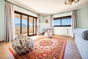 A spacious room with a large window, a patterned rug, and a sofa. - CostaBlancaDreams - Villa Los Pinos in Calpe (Calpe)