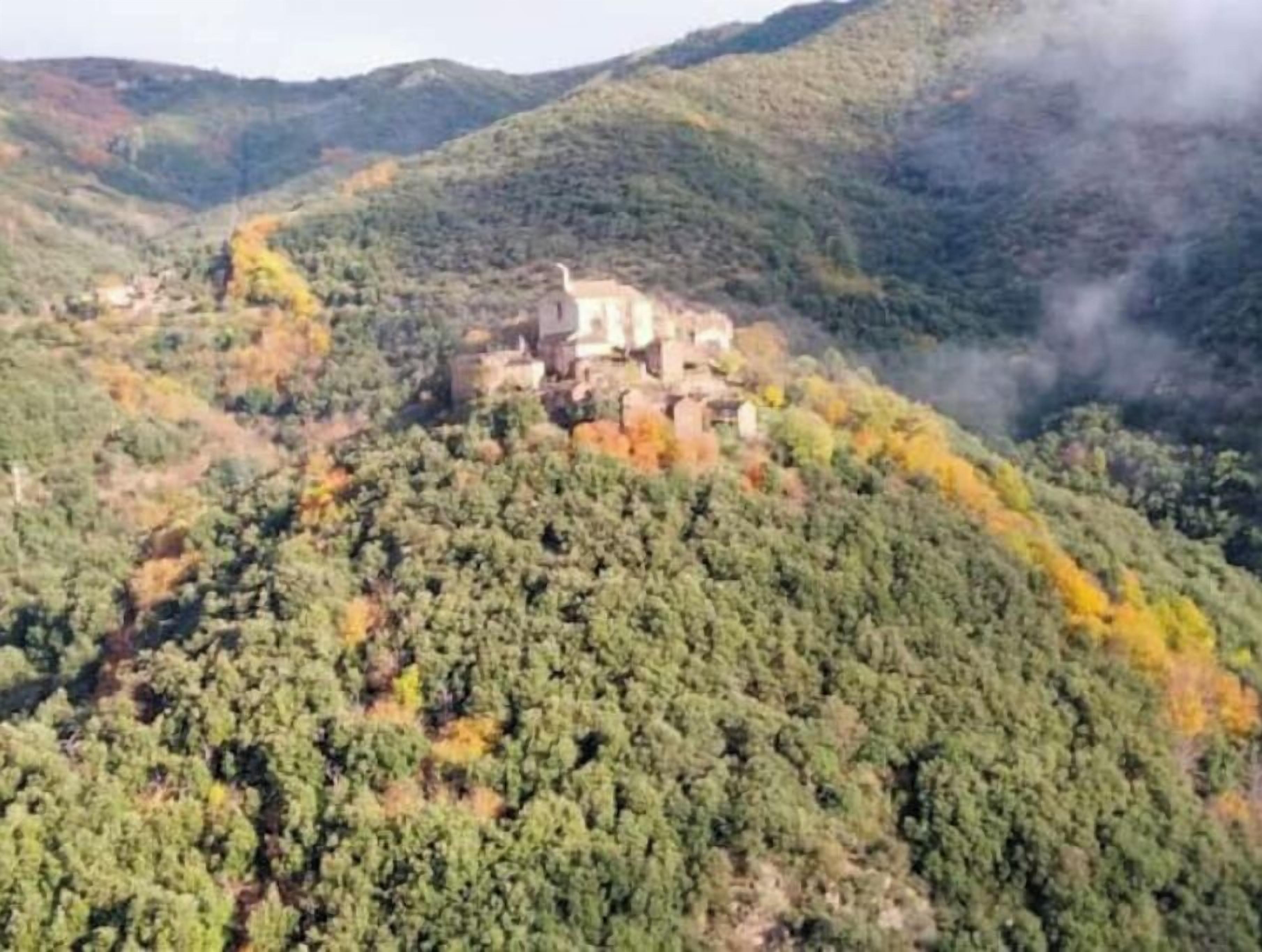 A mountainous landscape with a historic building on a hill.