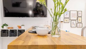 Un tavolo da pranzo con ciotole, un vaso con fiori e quadri appesi al muro.