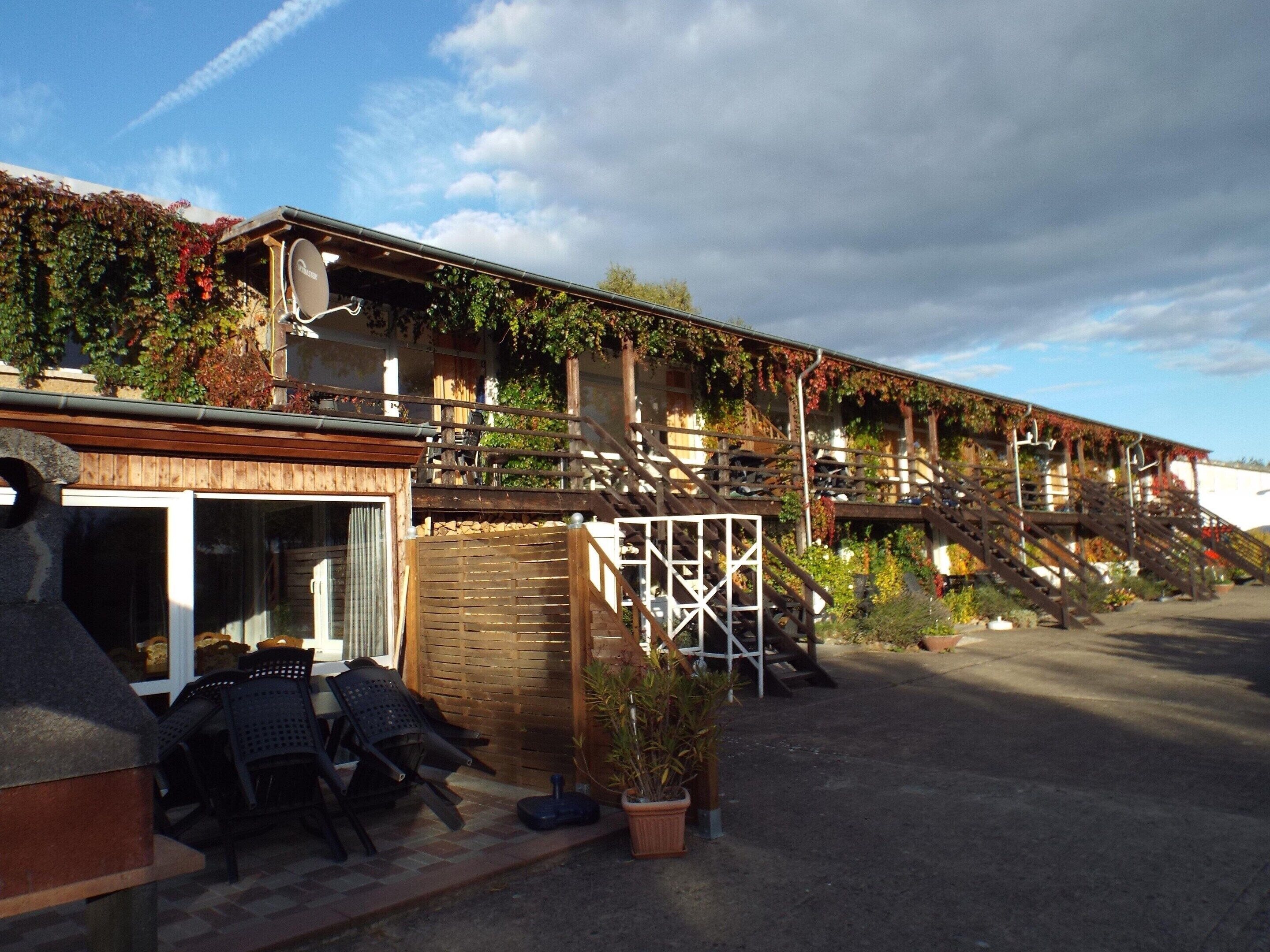 Ein Gebäude mit Holzfassade, Außenbereich und einer Treppe zu einem Balkon.